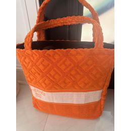 Bright orange towel-textured geometric tote with padded handles and a wide cream woven stripe
