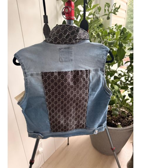Back view of size Medium light wash denim vest with contrast black and cream repeating pattern back panel