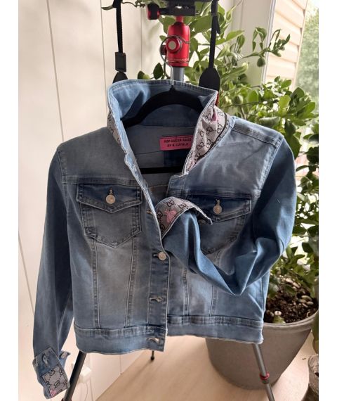 Front view of medium light-wash denim jacket with gray and pink bee-patterned collar and cuff