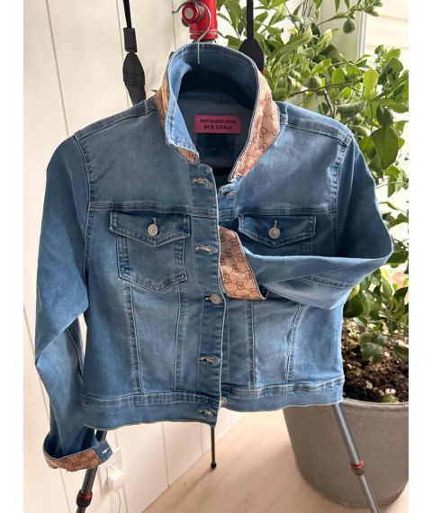 Front of medium blue denim jacket with contrast sand patterned collar and rolled cuffs