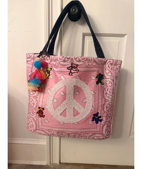 Pink bandana tote with beaded peace sign, colorful dancing bear patches, black shoulder straps and multicolor tassel